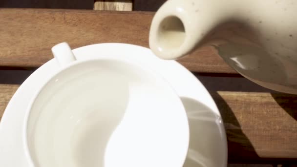 Tasse auf einer Untertasse auf einem Holztisch am Morgen — Stockvideo