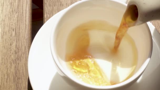 Tasse auf einer Untertasse auf einem Holztisch am Morgen — Stockvideo