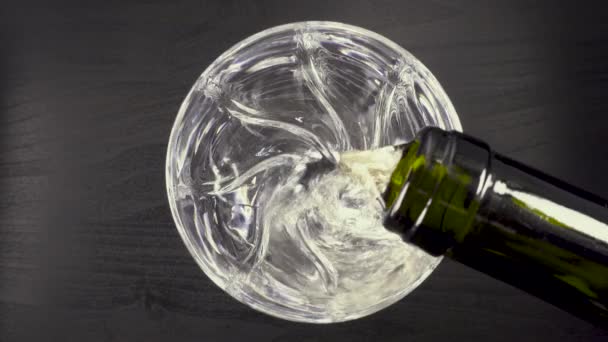 Dans un verre sur fond noir versant du vin d'une bouteille — Video