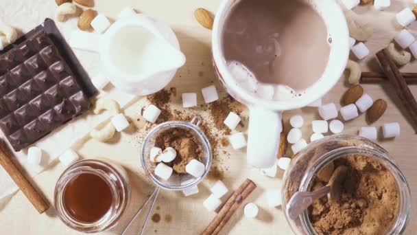 Sobre una mesa de madera una taza blanca e ingredientes para cacao — Vídeo de stock