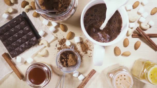 На деревянном столе белая кружка и ингредиенты для замедленного какао — стоковое видео