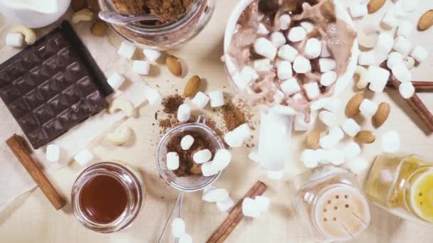 На деревянном столе белая кружка и ингредиенты для замедленного какао — стоковое видео