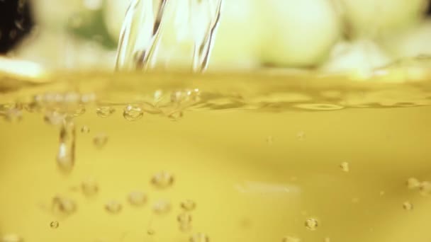 ガラスのクローズ アップ スローモーションに白ワインと黄色のフルーツ ジュースを注ぐの流れ — ストック動画