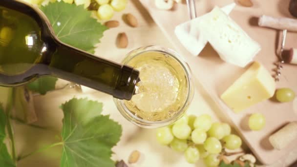 Ein Glas und eine Flasche Wein und ein Snack Draufsicht — Stockvideo