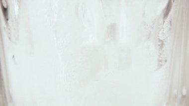 Buz yakın çekim ağır çekim bir bardak suya dökmek