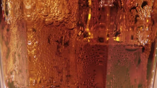 Bebida carbonatada en un vaso con hielo de cerca — Vídeos de Stock