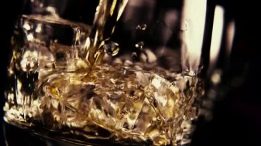 Ağır çekim bir bardak buz bourbon dökün