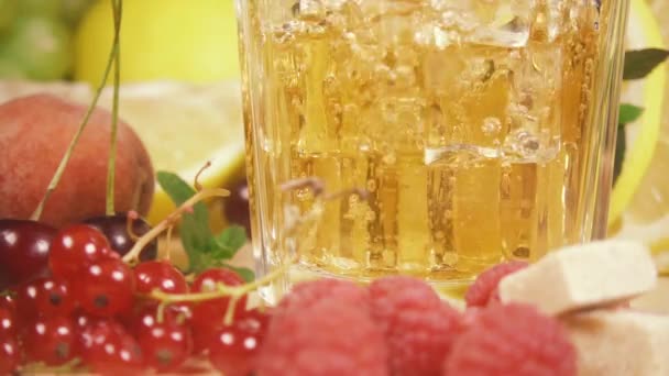 Bebida en cámara lenta de color amarillo verter en un vaso de hielo — Vídeo de stock