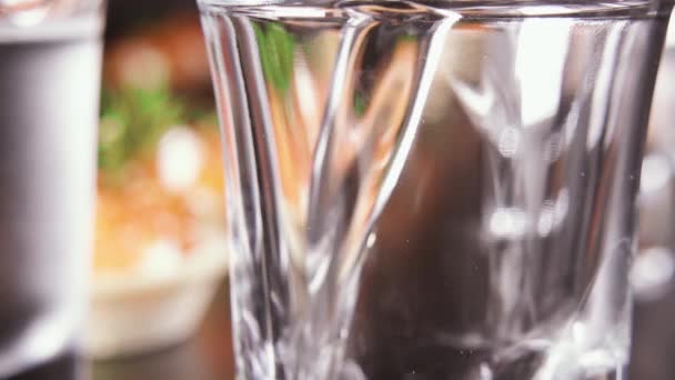 Sklenici vodky na stůl s občerstvením — Stock video