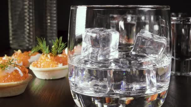 Un vaso de vodka en la mesa con un aperitivo — Vídeos de Stock