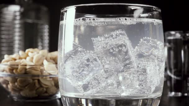 Zpomalený pohyb sklenici vodky na stůl s občerstvením — Stock video