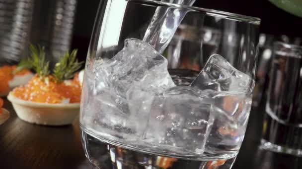 Movimento lento um copo de vodka na mesa com um lanche — Vídeo de Stock