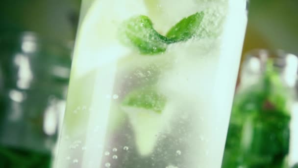 Slow motion bubbles in a glass of sparkling water and lime — Stock Video