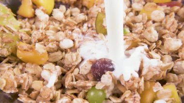 Ağır çekimde meyve parçaları ile müsli süt dökün