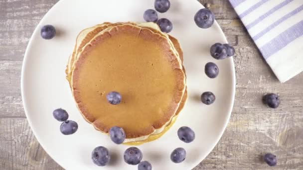 Slow motion pannenkoeken voor ontbijt met bessen en honing bovenaanzicht — Stockvideo