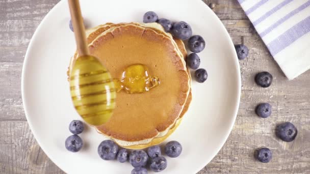 Pfannkuchen in Zeitlupe zum Frühstück mit Beeren und Honig von oben — Stockvideo