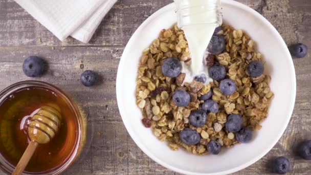 Lassú mozgás kész reggeli tej, a méz és a bogyók felülnézet — Stock videók