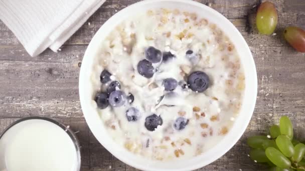 Petit déjeuner prêt au ralenti avec lait, miel et baies vue de dessus — Video