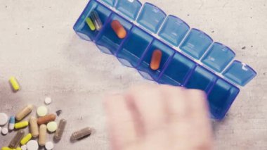 Yaşlı bir kadın hapları hücrelerin üst görünümünde koyar.