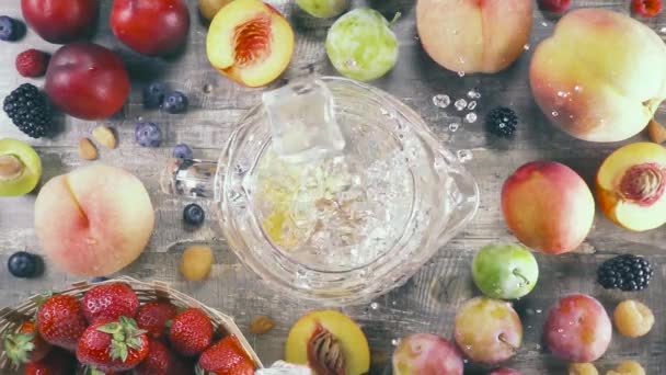 Bebida de fruta en cámara lenta con hielo en una vista superior de vidrio — Vídeo de stock