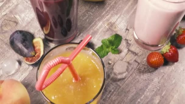 Fruit smoothies op de tafel in de buurt van het bovenaanzicht van de vruchten — Stockvideo