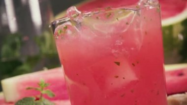 Ağır çekimde karpuz suyu ve nane Ice cube bir bardak düşüyor