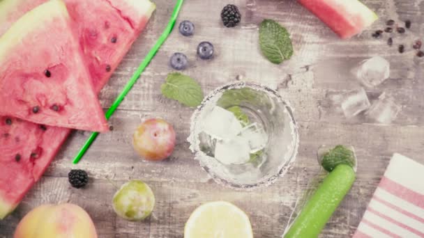 Mouvement lent dans un verre avec un bord confit et des feuilles de menthe vue de dessus des chutes de glace — Video