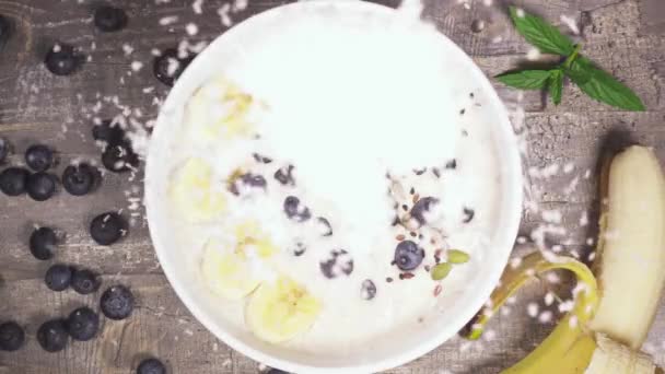 Mouvement lent dans un bol de smoothie aux fruits vue du dessus de la noix de coco — Video