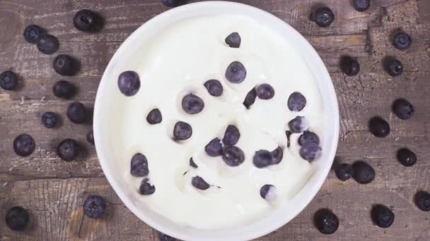 Zeitlupe in einer Schüssel mit Joghurt fallenden Beeren Draufsicht — Stockvideo