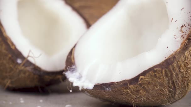 Leite de coco em câmara lenta e metades de coco — Vídeo de Stock