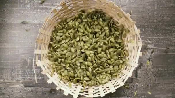 Les graines de citrouille pelées à mouvement lent tombent dans le panier vue du dessus — Video