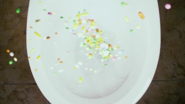 Lento movimento jogar pílulas na vista superior do vaso sanitário — Vídeo de Stock