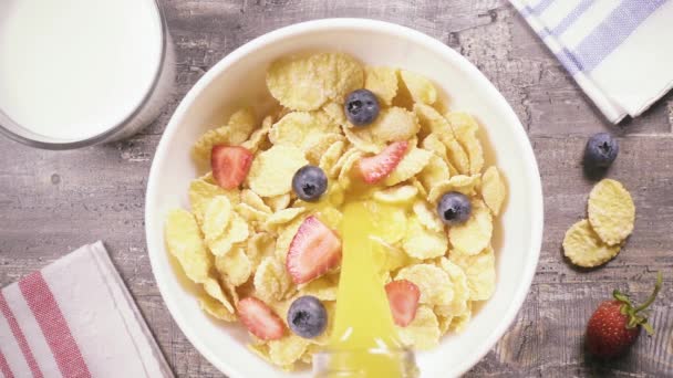 Slow motion cornflakes met bessen giet vloeistof bovenaanzicht — Stockvideo