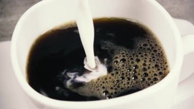 Ağır çekim köpük yakın çekim ile kahve içine süt dökün