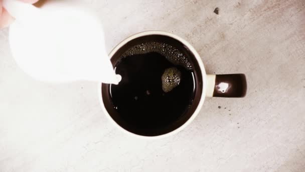 Медленное движение вылить молоко в чашку кофе вид сверху — стоковое видео