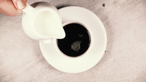 Mouvement lent verser le lait dans le café noir vue du dessus 