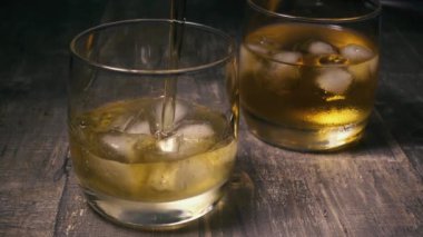 Ağır çekimde bir bardak buzlu viski doldur