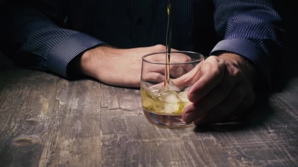 Ralentir un homme tenant un verre de glace et verser du whisky — Video