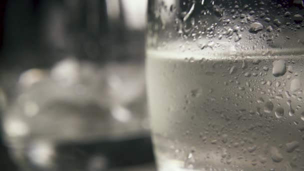 Slow motion drops on wet glass with clear drink close-up — Stock Video