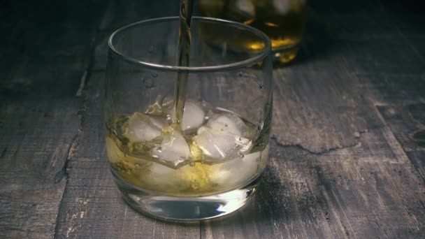 Медленное движение в стакане со льдом налить спирт — стоковое видео
