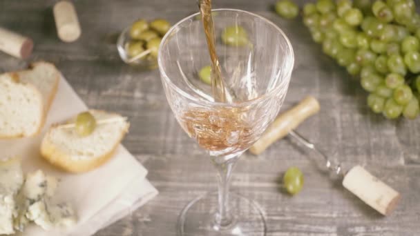 慢动作将葡萄酒倒入水晶玻璃杯附近的奶酪和葡萄顶部视图 — 图库视频影像
