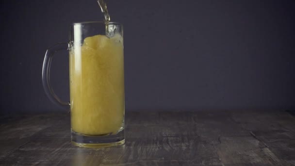 Slow motion pour light bier in een mug op een grijze achtergrond — Stockvideo