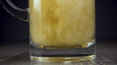 Ağır çekim pour light bira bir kupa gri arka plan yakın tarih
