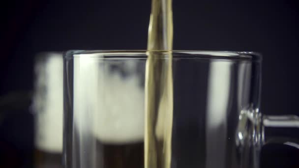 Zeitlupe gießt leichtes Bier in einen Becher auf grauem Hintergrund in Großaufnahme — Stockvideo