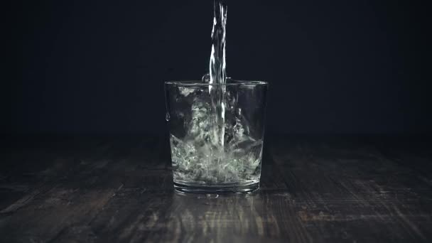 A água limpa é lindamente derramada em um copo — Vídeo de Stock