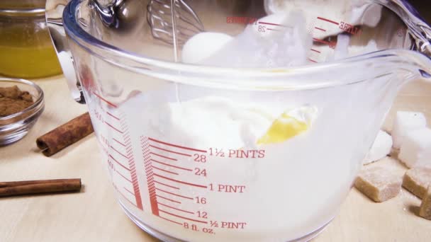 Slow motion glass measuring cup on the table near the ingredients — Stock Video