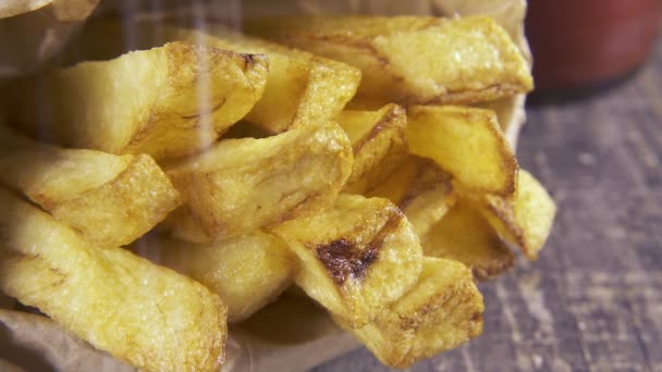Rociar sal en cámara lenta sobre papas fritas de cerca — Vídeos de Stock