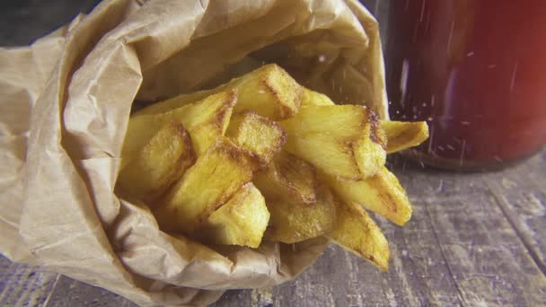 Patatas en cámara lenta en un paquete espolvorear con sal — Vídeos de Stock