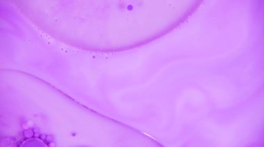 Küçük ve büyük güzel mor baloncuklar bir büyük petrol daire içinde rasgele bir ışık Lila arka plan üzerinde hareket