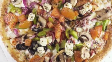 Bir daire üst görünümünde bir karton kutu içinde bitmiş pizza döner